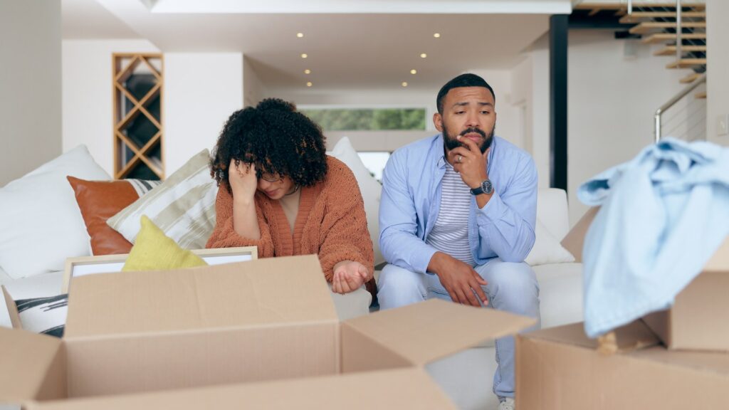 Couple feeling stressed while packing moving boxes