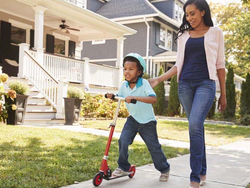 Mother-and-Son-Scooter-on-Suburb-Sidewalk