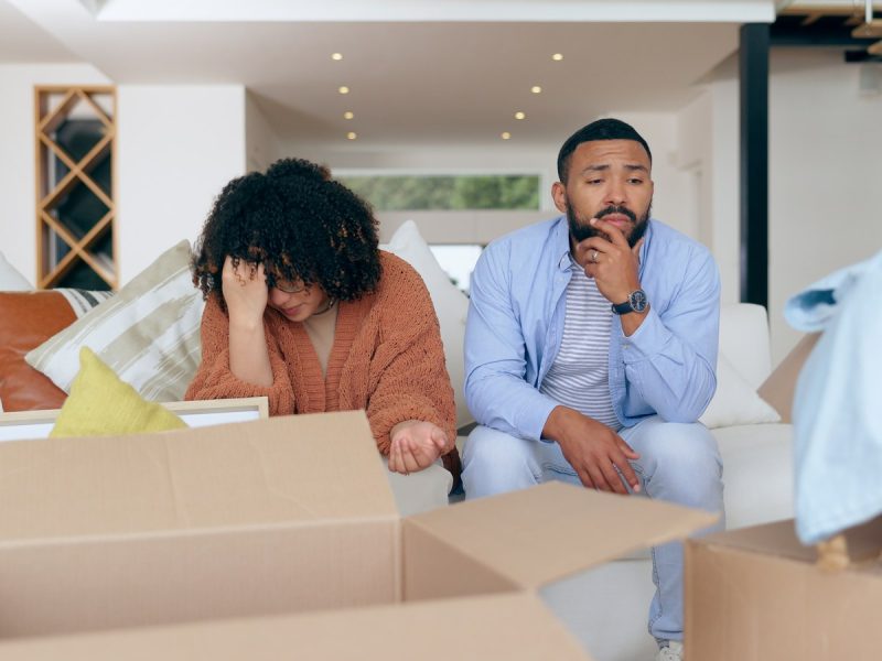 Couple feeling stressed while packing moving boxes