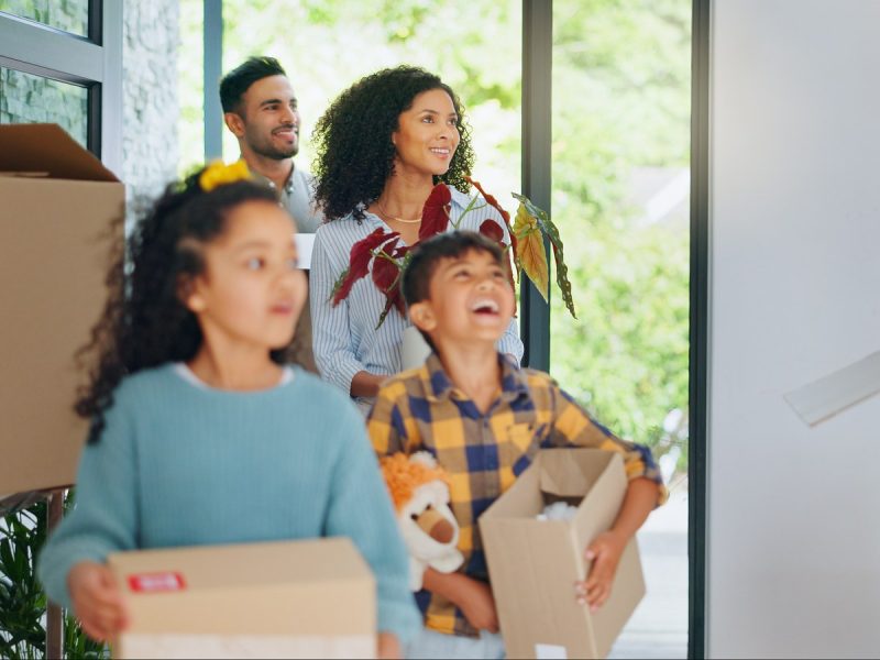 Family with children unpacking boxes in a new home